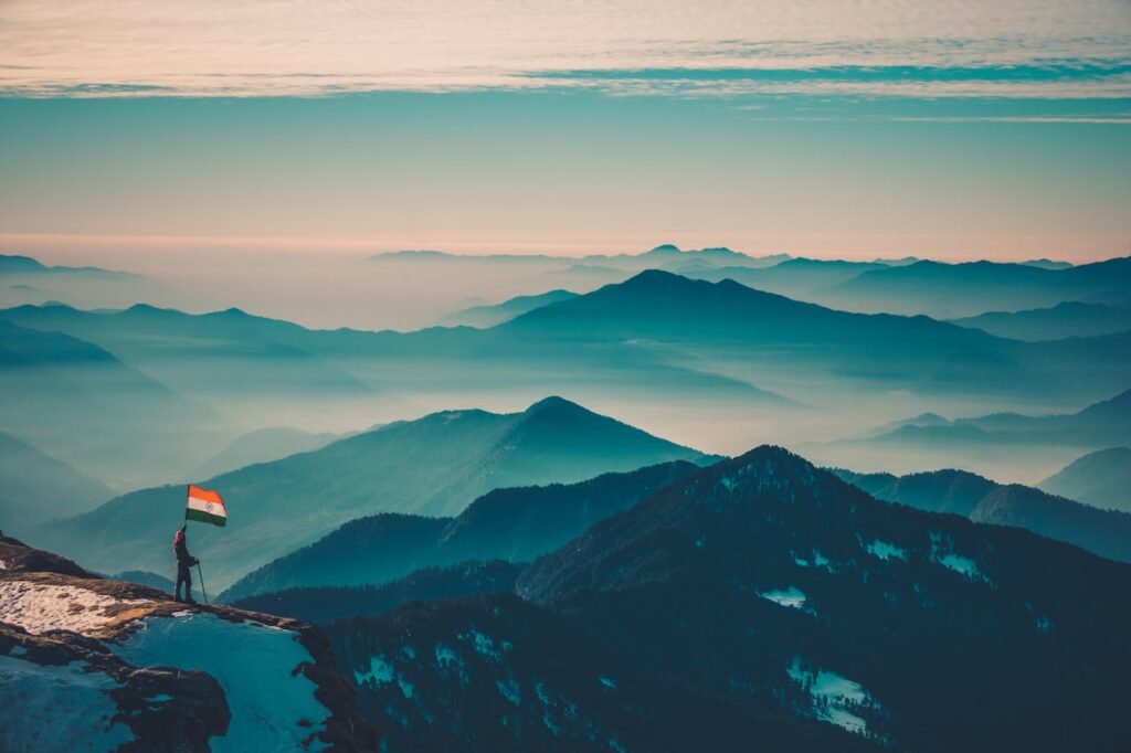 Mountain Peaks Under Blue Sky with White Clouds